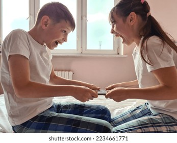 Little boy and girl fight for touchpad computer addiction. Brother sister fight over gadget - Powered by Shutterstock