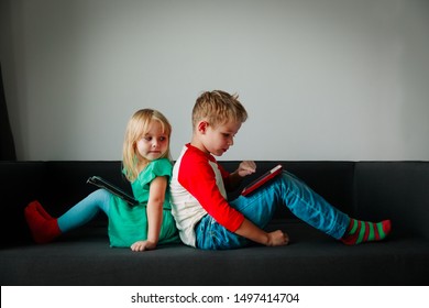 little boy and girl looking at touch pad at home