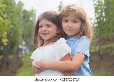 Little boy and girl in love. Cheerful kids playing on park outdoors. Summer portrait of happy cute children. Lovely child, first kids love. Happy childhood. Kids friendship and kindness.