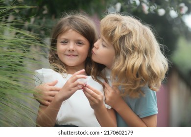 Little boy and girl in love. Cheerful kids playing on park outdoors. Summer portrait of happy cute children. Lovely child, first kids love. Happy childhood. Kids friendship and kindness.