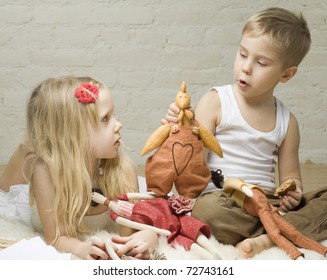 Little Boy And Girl Playing With Handmade Stuffed Animals