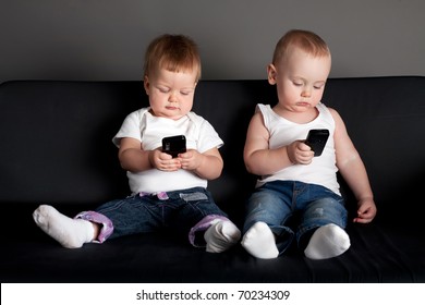 little boy and girl playing with mobile phones