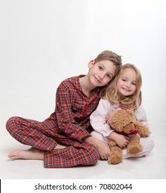 Little boy and girl in their pajamas with a teddy bear