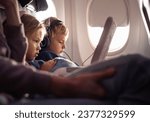 little boy girl travel by plane. Cute Kids sit at the window of an airplane and use a digital tablet during the flight. Family Traveling abroad with children
