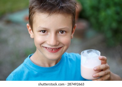 Little Boy With Glass Of Milk Outdoor Portrait