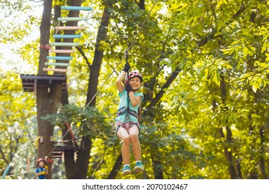 The Little Boy Goes Down The Zipline In The Park