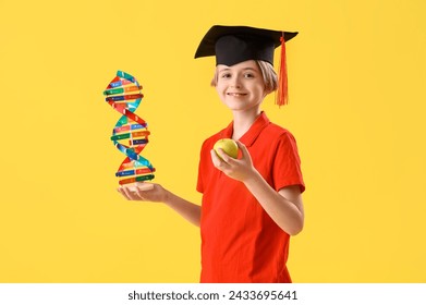 Little boy in graduation hat with apple and DNA model on yellow background. End of school year - Powered by Shutterstock