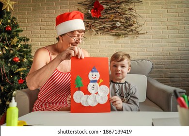 A Little Boy With Grandmother Show Christmas Craft, Greeting Card. Christmas Tree And Decoration On Background.