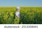 Little Boy In A Hat In Yellow Field Of Rapeseed. A Cute Little Boy In An White Hat On A Blooming Rapeseed Field. Countryside.