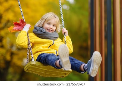 Little boy having fun on a swing on the playground in public park on autumn day. Happy child enjoy swinging. Active outdoors leisure for child in city - Shutterstock ID 2175578707
