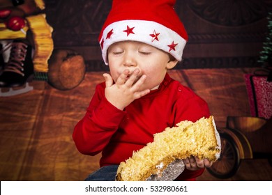 Little Boy Having Fun While He's Eating A Christmas Cake.