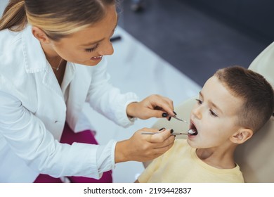 Little Boy Having Regular Dental Check-up. Cute Boy Smiling While Teeth Exam . Happy Boy Sitting In Dentists Chair And Having Check Up Teeth. Portrait Of Smiling Little Boy Sitting In Dental Chair