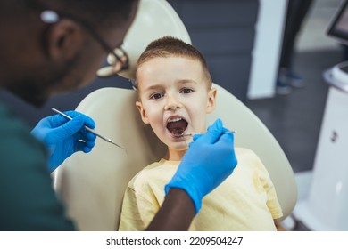 Little Boy Having Regular Dental Check-up. Cute Boy Smiling While Teeth Exam . Happy Boy Sitting In Dentists Chair And Having Check Up Teeth. Portrait Of Smiling Little Boy Sitting In Dental Chair 