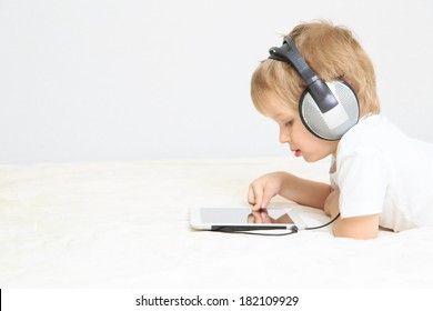 little boy with headset using touch pad, early education and learning