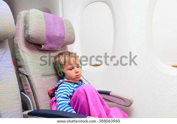 little boy with\
headset watching tv in\
flight
