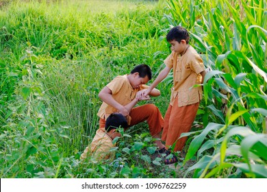 Little Boy Helping Another Boy By Pulling Hand Up