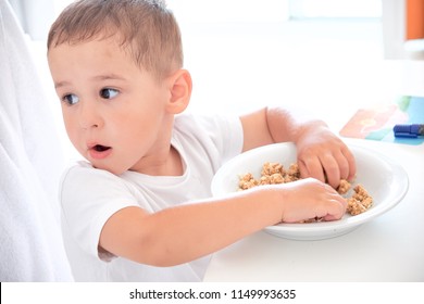 Little Boy Helps Dad Pour Milk Into Oatmeal. Quick Breakfast At Home