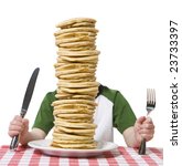 Little boy hidden behind  a giant plate of pancakes, with a knife and fork visible on a table cloth.