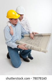 Little Boy And His Dad With Safety Helmets Consulting A Plan