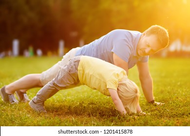 Little boy and his father doing plank exercise in sunny summer park. Outdoor sport activities for family with kids. - Powered by Shutterstock