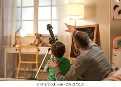 Little boy and his father looking at stars through telescope in evening - Powered by Shutterstock