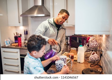 Little Boy And His Father Are Making Tea For Breakfast At Home.