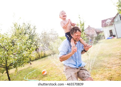 Little Boy With His Father At The Sprinkler, Summer