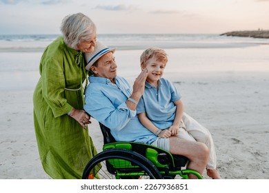 Little boy with his granfather on wheelchair, having fun and enjoying sea together. - Powered by Shutterstock