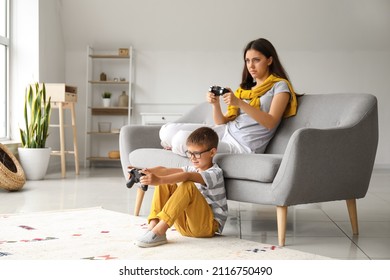 Little Boy With His Older Sister Playing Video Game At Home