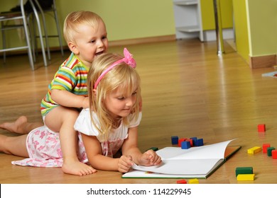 Cute Baby Boy Playing With His Sister With Toys In The Sandbox Outdoor