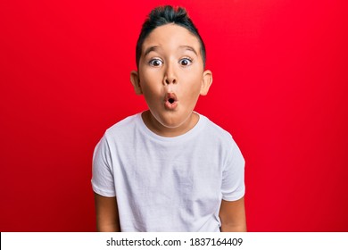 Little Boy Hispanic Kid Wearing Casual White Tshirt Scared And Amazed With Open Mouth For Surprise, Disbelief Face 