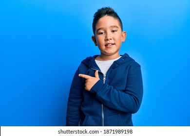 Little boy hispanic kid wearing casual sporty jacket smiling cheerful pointing with hand and finger up to the side 