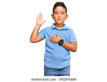 Little Boy Hispanic Kid Wearing Casual Clothes Swearing With Hand On Chest And Open Palm, Making A Loyalty Promise Oath 