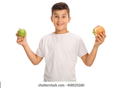 Little Boy Holding An Apple In One Hand And A Sandwich In The Other Isolated On White Background