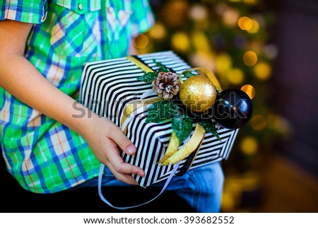 little boy holding a Christmas gift (close up)