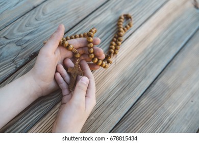 Little Boy Holding Old Wooden Rosary. Child Praying