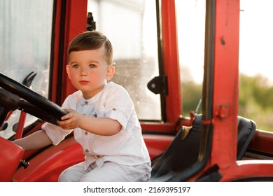 Little Boy Holding A Tractor Steering Wheel At Sunset