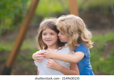 Little boy hugging shy girl, toddler boy embracing depressed little girl, relationship, friendship concept. Hugging kids outdoor. Lovely children. First love.