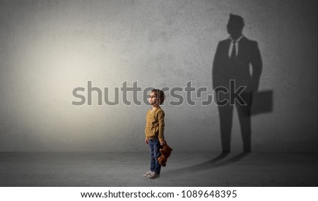 Little boy imagine that he will be businessman and illustrating his future in a big shadow