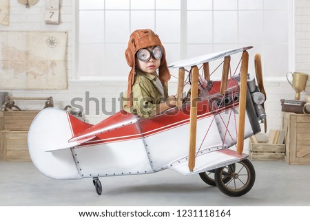 Little boy imagines himself as an airplane pilot in the children's room.