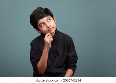 Little Boy Of Indian Ethnicity Looking Up And Thinking