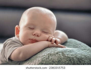 A little boy, an infant sleeping on a heart-shaped pillow with his little hands under his head. - Powered by Shutterstock