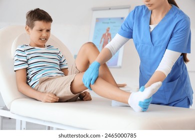 Little boy with injured leg visiting doctor in clinic - Powered by Shutterstock