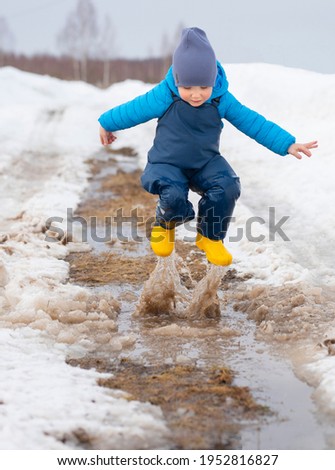 Little boy jump in the puddle