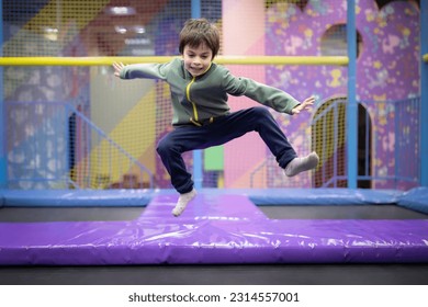 Little boy jumping and having fun on trampoline in amusement center for kids - Powered by Shutterstock