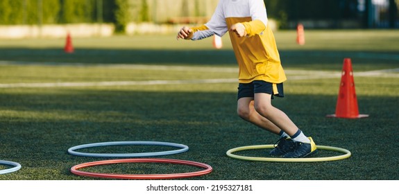 Little Boy Jumping Over Obstacles Hula Hoops On Kids Sports Education Class. A Child Having Fun At Outdoor Sport Training