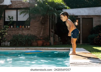 Little boy jumping in a pool. Child get fun in the swimming pool of his home. - Powered by Shutterstock