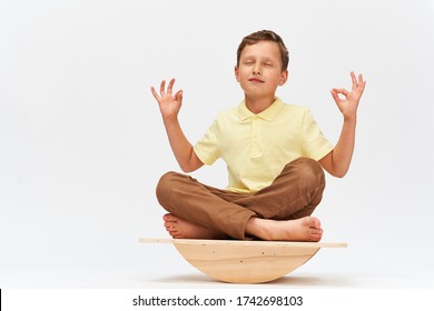 Little Boy Keeps His Balance On A Special Simulator For Training Muscles. Child Is Engaged On The Balance Beam, Intermediate Internal Balance. Training Of Child's Brain, Development Of The Cerebellum.