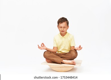 Little Boy Keeps His Balance On A Special Simulator For Training Muscles. Child Is Engaged On The Balance Beam, Intermediate Internal Balance. Training Of Child's Brain, Development Of The Cerebellum.