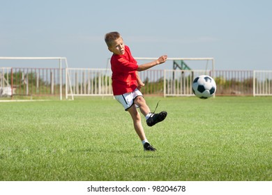 Little Boy Kicking At Goal